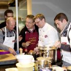 Teilnehmer des Kochkurses um eine Kücheninsel